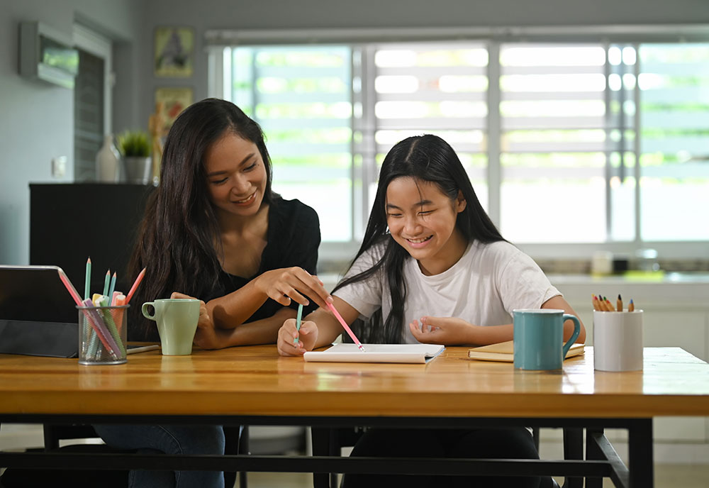Woman helping girl with reading